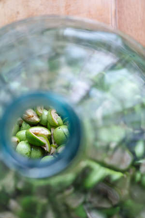 Step-by-step recipe for preparing of homemade Italian liquor nocino from green walnuts, real home kitchen and cooking, selective focusの写真素材