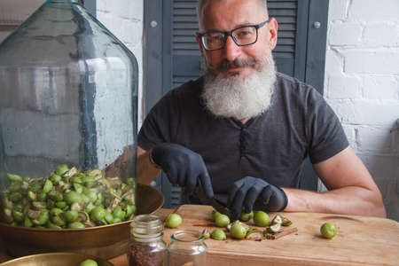 Step-by-step recipe for preparing of homemade Italian liquor nocino from green walnuts, real home kitchen and cooking, selective focusの写真素材