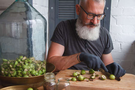 Step-by-step recipe for preparing of homemade Italian liquor nocino from green walnuts, real home kitchen and cooking, selective focusの写真素材