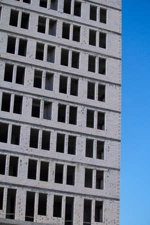 New multi-storey ready for commissioning white brick building against blue sky, free space for textの写真素材