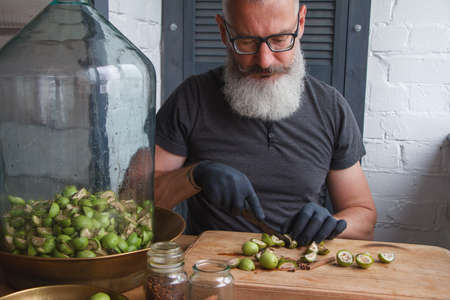 Step-by-step recipe for preparing of homemade Italian liquor nocino from green walnuts, real home kitchen and cooking, selective focusの写真素材