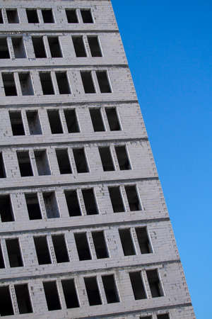 New multi-storey ready for commissioning white brick building against blue sky, free space for textの写真素材
