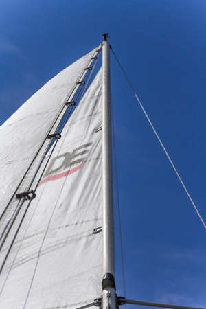 Kharkiv, Ukraine - July 28, 2020: Bottom view of mast and sail of yacht on blue sky backdrop, selective focusのeditorial素材