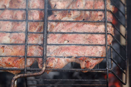Close up beef or pork meat barbecue prepared grilled on bbq fire flame grill, view from aboveの写真素材
