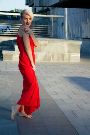 Happy beautiful woman in red dress with various emotions close up portraitの写真素材