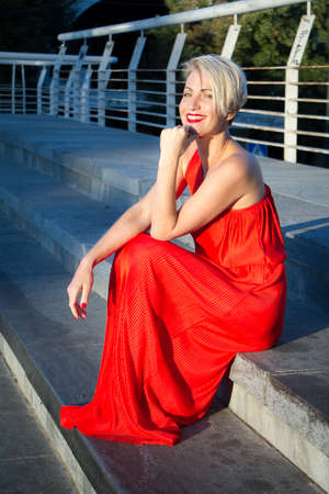 Happy beautiful woman in red dress with various emotions close up portraitの写真素材