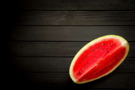 Slice of ripe red watermelon on black background, top viewの写真素材