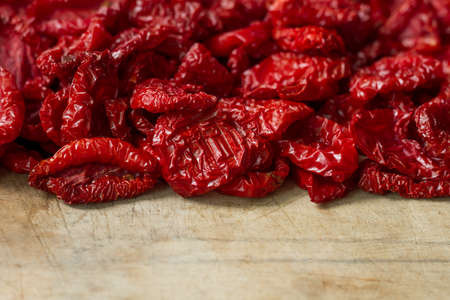 Close up sundried tomatoes with spices and olive oil on wooden cutting board, background or concept, selective focusの写真素材