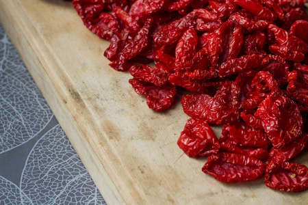 Close up sundried tomatoes with spices and olive oil on wooden cutting board, background or concept, selective focusの写真素材