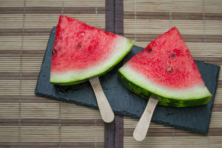 Watermelon fresh slice on black stone plank, ice cream concept, selective focusの写真素材