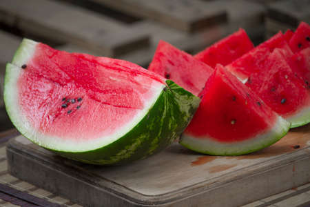 Fresh red ripe watermelon on wooden cutting board, picnic concept, selective focusの写真素材