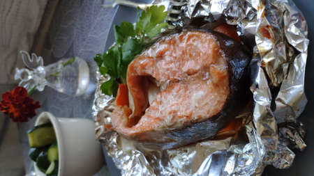 Homemade foil baked salmon steak with herbs, home cooking concept, selective focusの写真素材