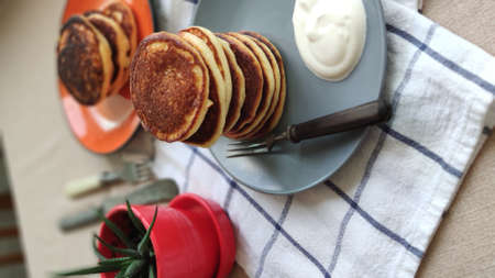 Grey plate with stack of homemade pancakes and sour cream on wooden table, selective focusの写真素材