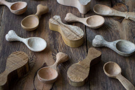 Handmade wooden kitchen utensils, side view lot of billets and spoons on wooden table, selective focusの写真素材