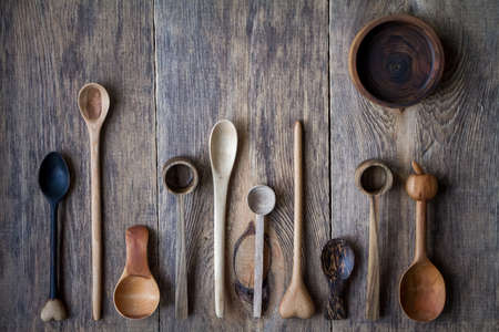 Top view lot of wooden spoons made of precious wood on wooden table, eco-friendly concept of cutlery, handmade tableware productionの写真素材