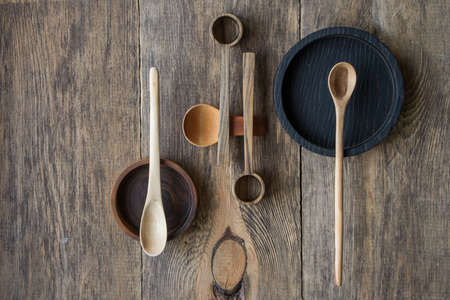 Top view wooden spoons and plates made of precious wood on wooden table, eco friendly cutlery concept, selective focusの写真素材