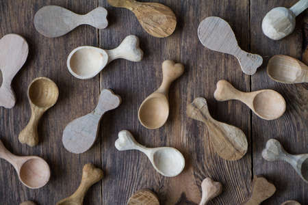 Handmade wooden kitchen utensils, top view lot of billets and spoons on wooden table, selective focusの写真素材