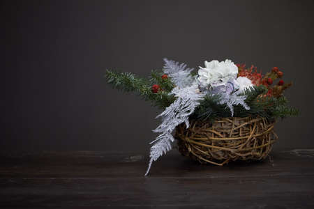 Christmas or New Year composition. Wicker basket with fir branches decorated by natural materials on grey backgroundの写真素材