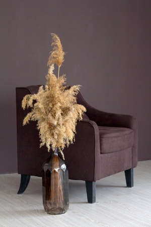 Stylish Scandinavian cozy minimalistic style interior, modern home decor, armchair, vase with pampas grass bouquetの写真素材