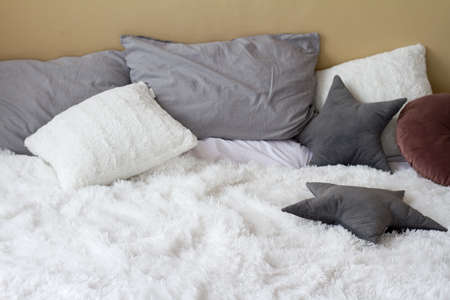 Comfortable bed with pillows in light bedroom, home comfort concept, copy spaceの写真素材