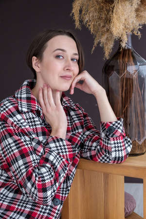 Studio portrait of young adult woman in warm home clothes, happy pregnancy concept, white backdropの写真素材