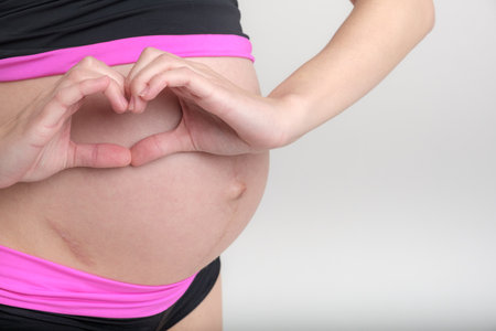 Young adult pregnant girl in sportswear. Sport and pregnancy concept. Yoga and fitness in...