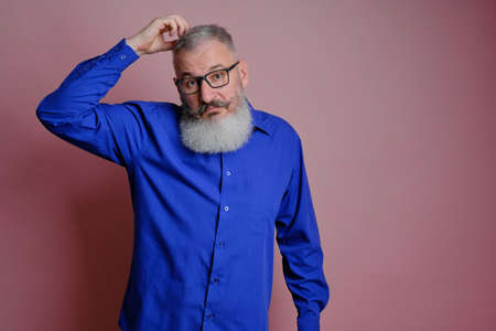 Mature man dressed in casual clothes looking surprised at camera, I cant believe my eyes concept, white backgroundの写真素材