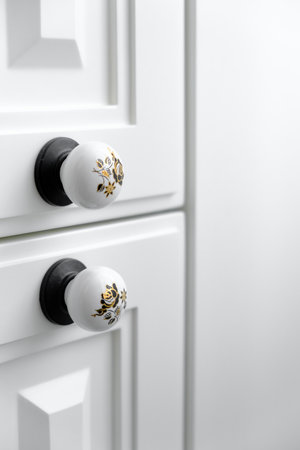 Extremely close up detail of vintage white cabinet, original ceramic handles, selective focus, copy spaceの写真素材