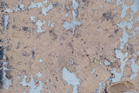 Old colorful beige paint with cracks on brick wall as background, texture, selective focusの写真素材