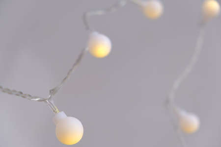 Close-up light chain decoration, festive lights garland, light bulbs on string wire, selective focusの写真素材
