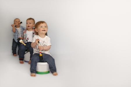 Children sit on large cans of paintの写真素材