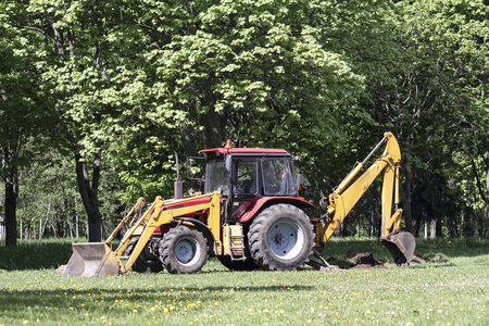 Red tractor and lawn mower, shears lawns in the alleys in the parkの写真素材