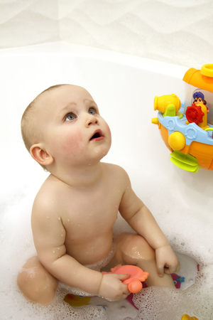 Portrait of a baby in the bathroom with toys for the bathroomの写真素材