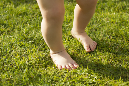 Baby's foot stepping on the grass for the first time.の写真素材