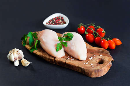Raw skinless chicken with tomatoes, parsley and garlicの写真素材