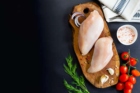 Raw skinless chicken with tomatoes, parsley and garlicの写真素材