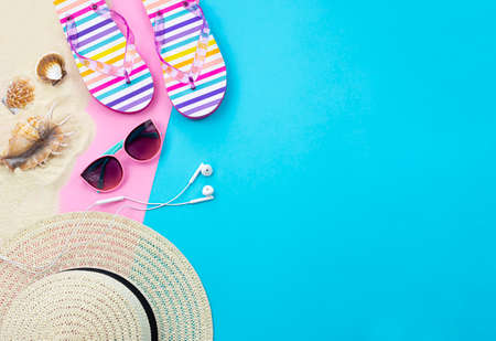 Trendy summer background with empty space for text. Summer leisure items are laid out on a blue and...
