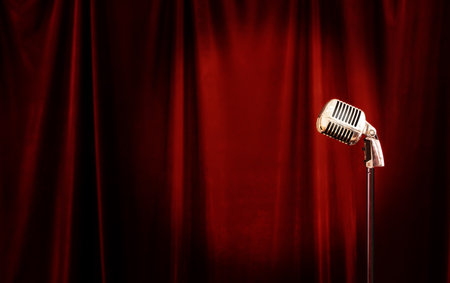 retro microphone is located on the background of a red velvet curtainの写真素材