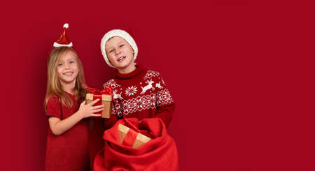 boy in sweater with traditional pattern with deer and girl in Christmas clothes and Christmas hats...