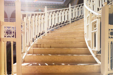 Beautiful front staircase close-up with decorative oriental style railings in a large house or...