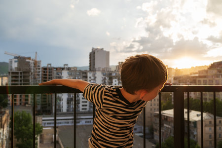 Unsupervised toddler climbing dangerous balcony railing Risky child behaviorの写真素材