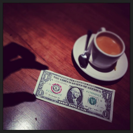 Shadowy hand seizes the moment and a dollar bill.