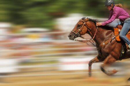 Panning shot of female racing a horse