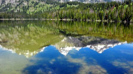 A reflection of the Grand Tetons in Taggart Lake. Grand Teton National Park, Wyoming
