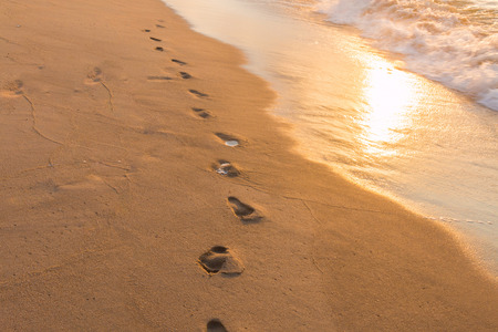 Footprints in the Sand reflective  at sunset time for backgroundの写真素材