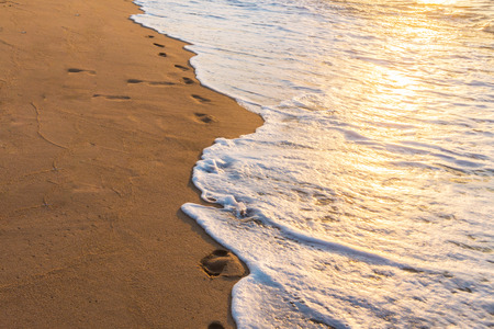 Footprints in the Sand reflective  at sunset time for backgroundの写真素材
