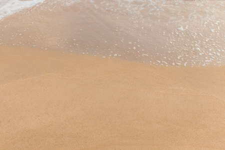 Closeup of sand and small wave  with lot of copy space for message backgroundの写真素材