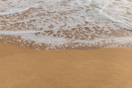 Closeup of sand and small wave  with lot of copy space for message backgroundの写真素材