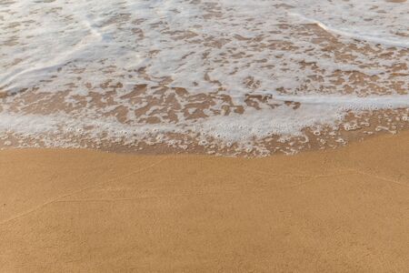 Closeup of sand and small wave  with lot of copy space for message backgroundの写真素材