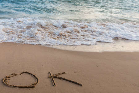 Wave of the sea on the sand beach with handwriting  for bacgroundの写真素材